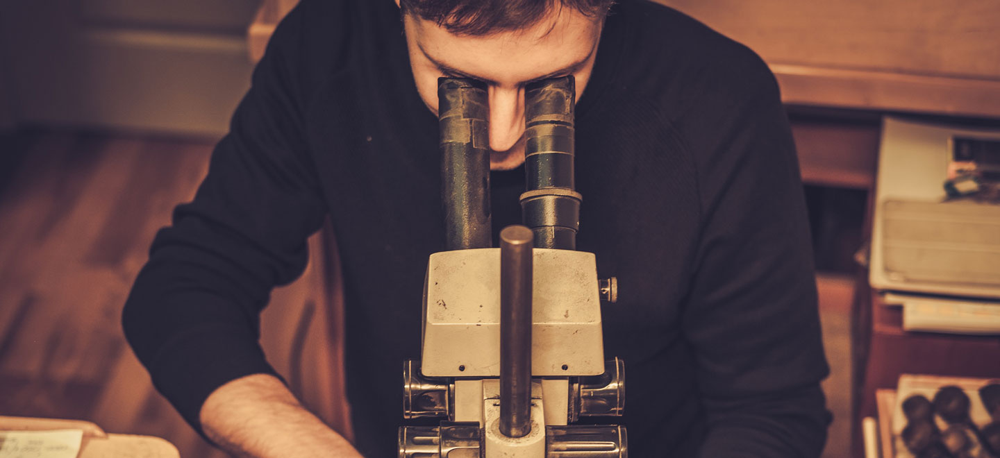 Jewelry student looking through a loop at a gemstone