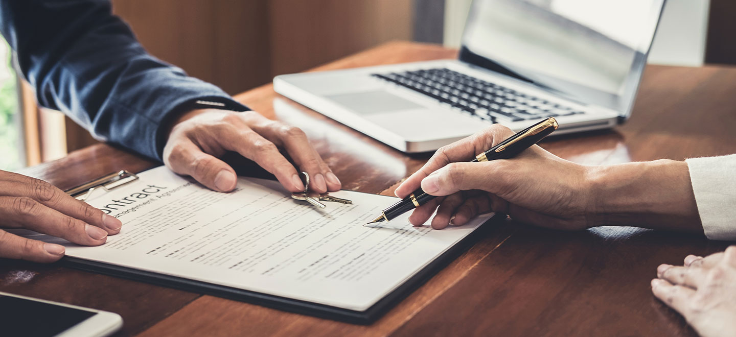 Two people signing a contract